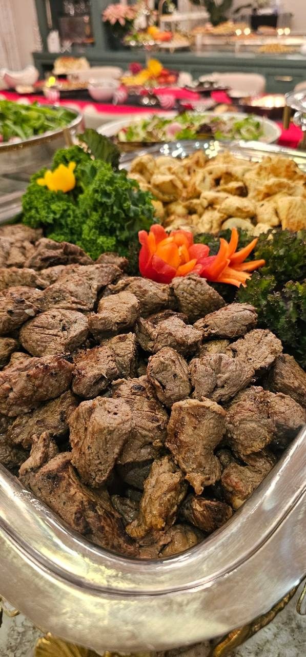 Seared beef bites on a silver platter garnished with carved carrot flowers