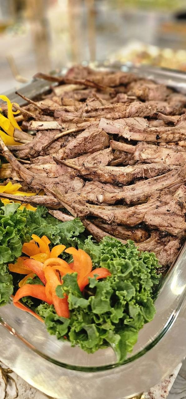 Sliced roast beef on a glass platter with kale and carved garnish