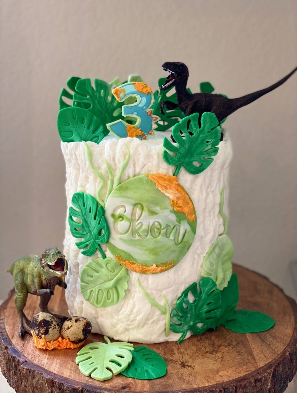 Dinosaur jungle birthday cake with monstera leaves