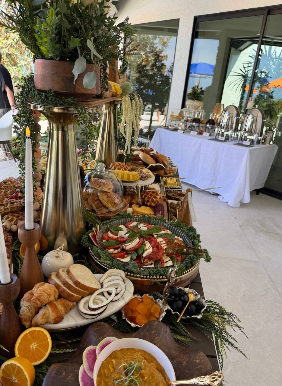 Garden grazing table with candles, greenery, breads and a bowl of soup