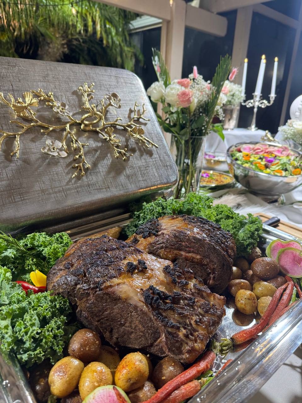 Roast prime rib with potatoes, radishes and kale beneath a gold-trimmed lid