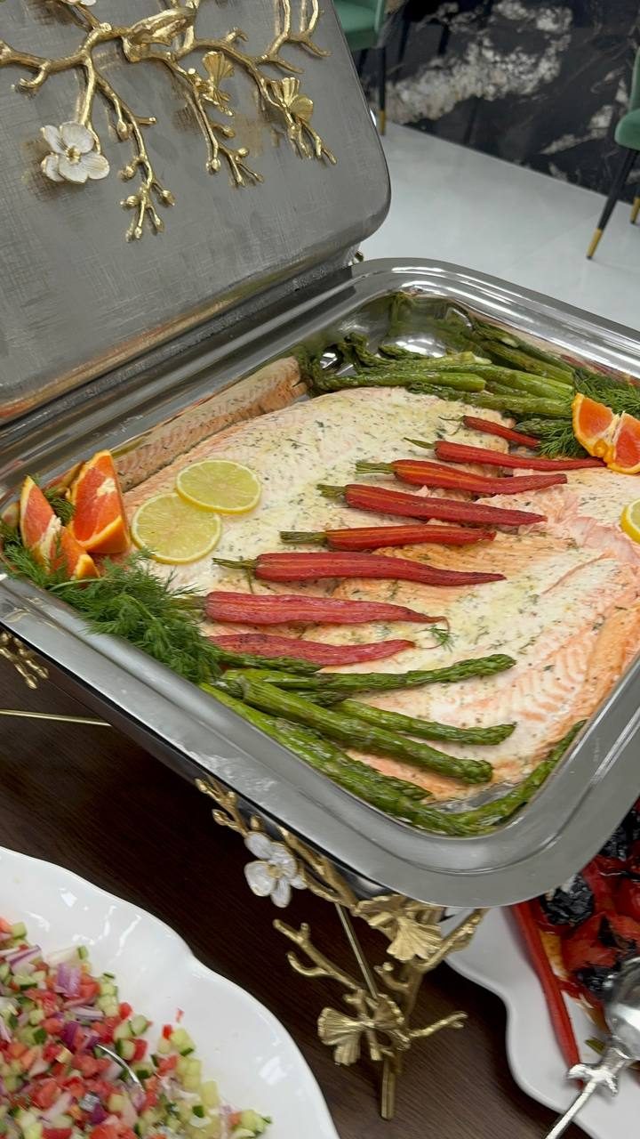 Poached salmon with asparagus, roasted carrots and citrus in a chafing dish